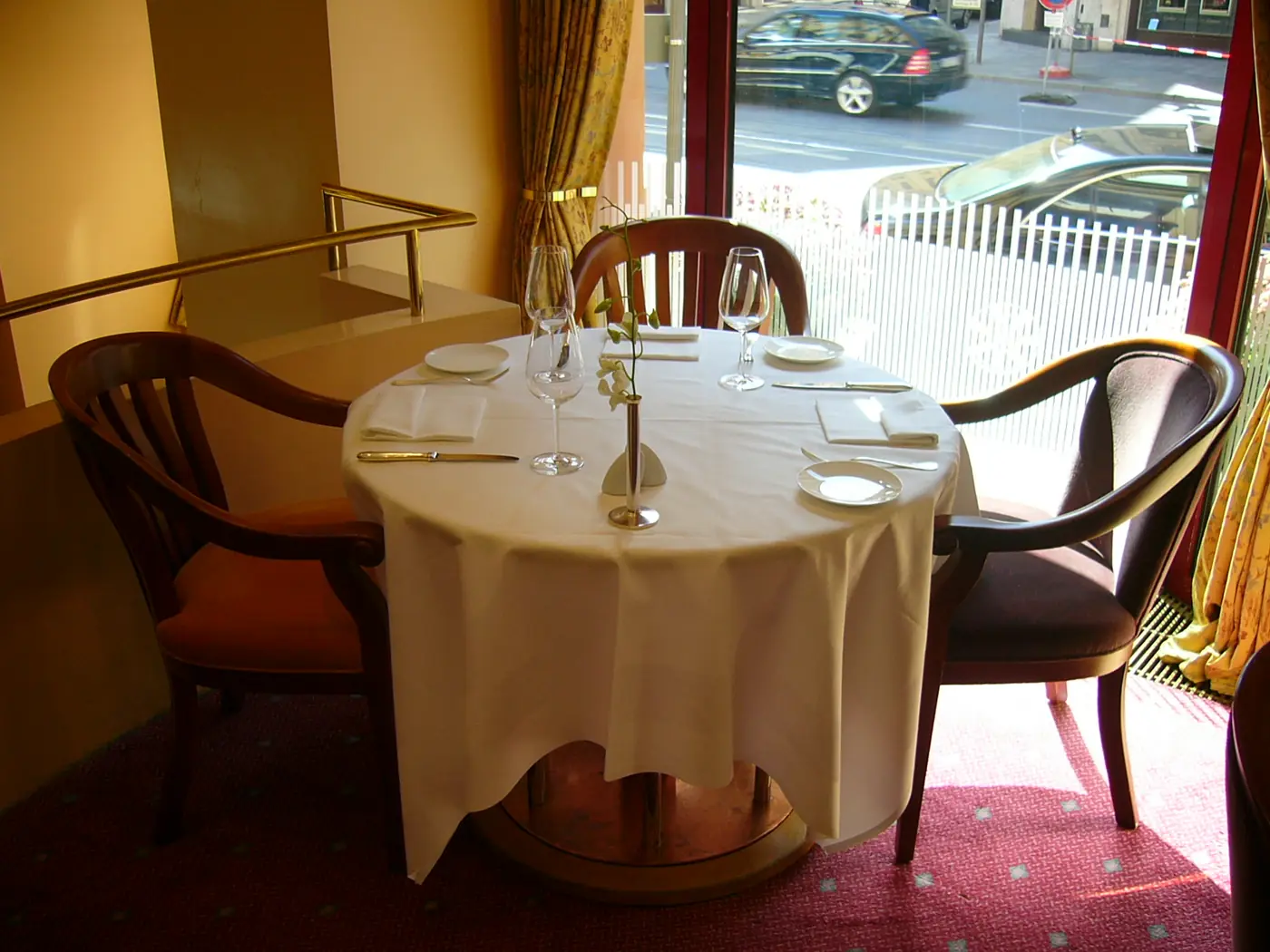Restaurant tables laid with white tablecloths and napkins