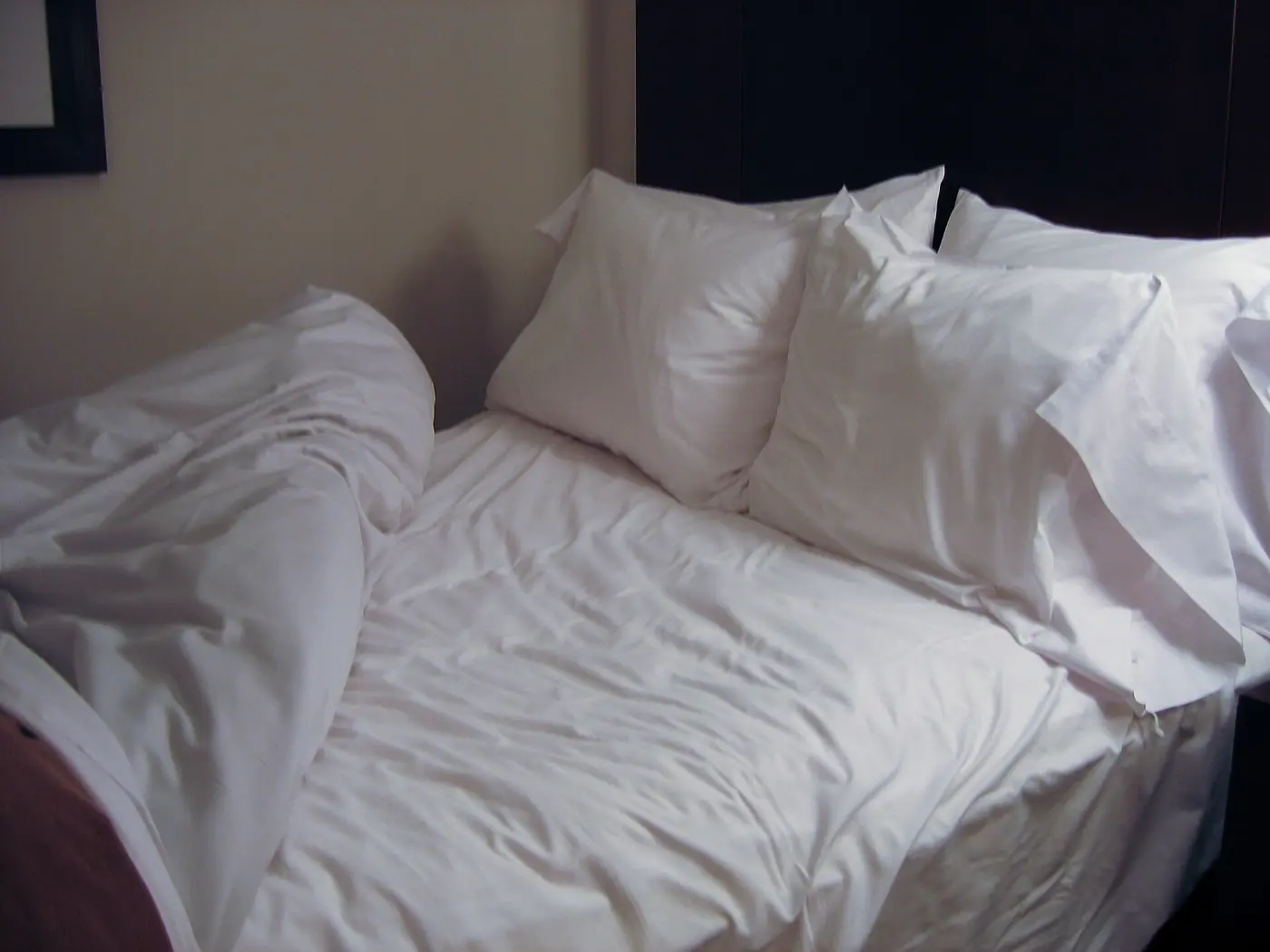 A bed with a fresh white duvet and pillows